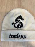 Bílá zimní čepice s černou výšivkou draka a nápisem fearless